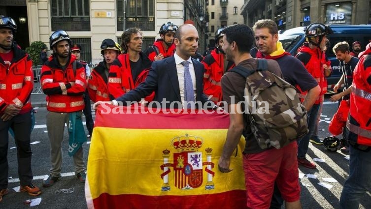 Con una bandera española en sus manos, un hombre expresa su apoyo a la policía española frente a la sede de la policía en Barcelona. (Foto: dpa)