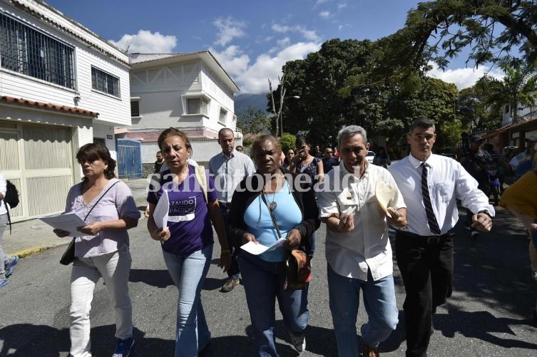 Opositores al régimen de Maduro reparten copias de la ley de amnistía en Caracas (AFP)