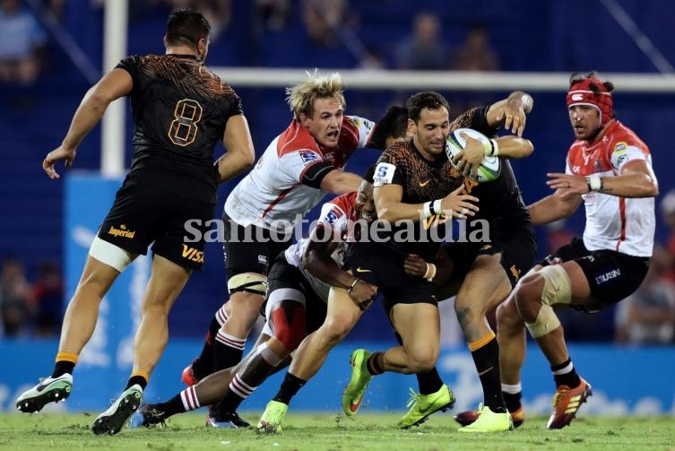 Joaquín Tuculet se lleva la ovalada contra un tackle del rival, mientras que Marnus Schoeman y Warren Whiteley acechan desde cerca en Liniers. Foto: AFP