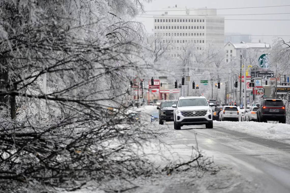 n conductor pasa junto a una rama llena de hielo por la avenida West End durante una tormenta invernal el domingo 25 de enero de 2026 en Nashville, Tennessee. (AP Foto/George Walker IV)