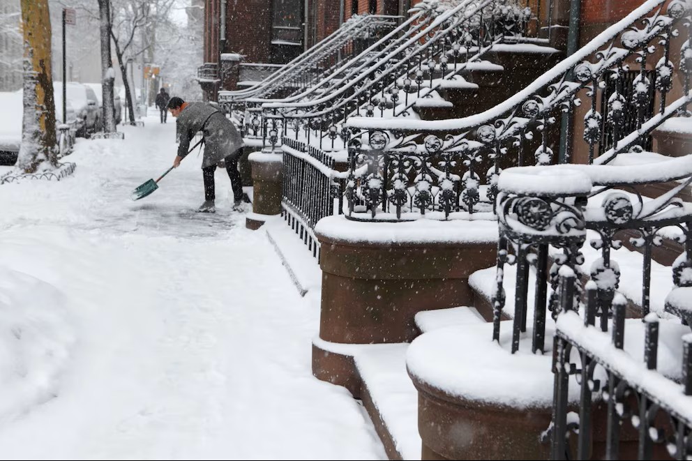Un residente despeja la vereda frente a su vivienda en un barrio de Nueva York, luego de las precipitaciones registradas durante el fin de semana.
