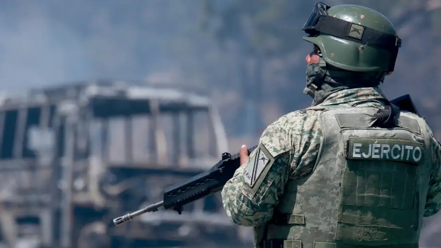 Un soldado del Ejército mexicano vigila una carretera cortada por un vehículo incendiado en Cointzio, Michoacán. (Foto: AP)