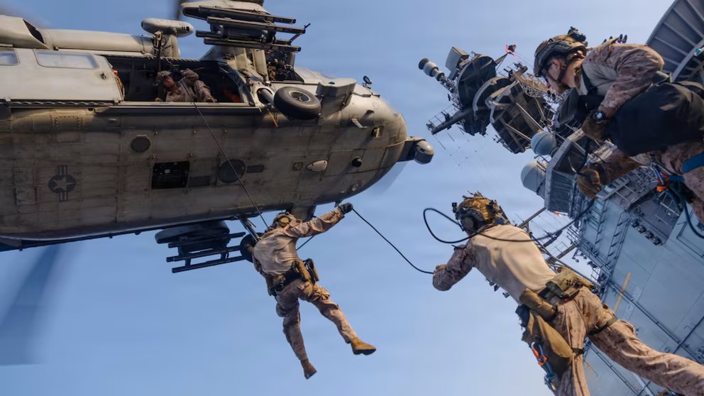 Marines de Estados Unidos descienden desde un helicóptero MH-60S Sea Hawk durante un ejercicio a bordo del buque de asalto anfibio USS Tripoli.